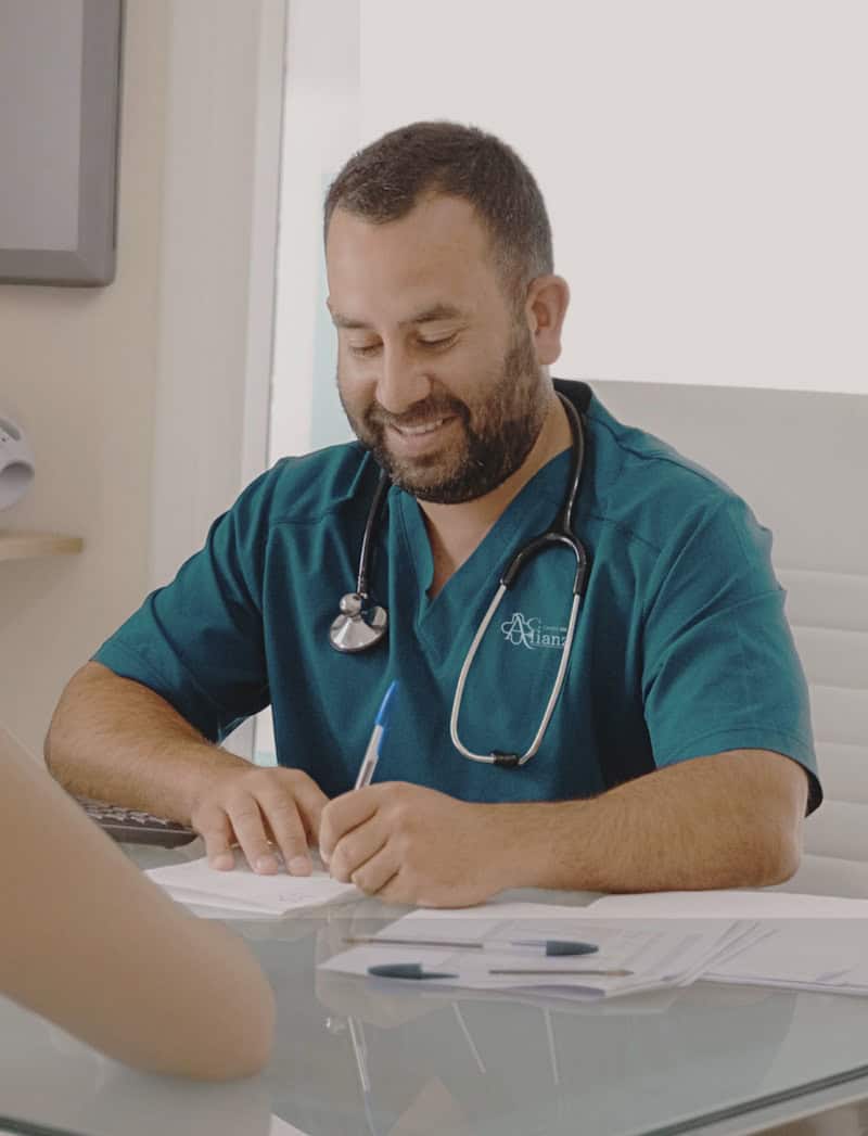 Traumatólogo en San Fernando durante una consulta, explicando el plan de tratamiento a una paciente.